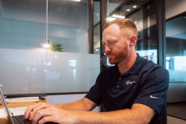 Homepage - About Core Insurance Solutions Working on Laptop at Desk in Office